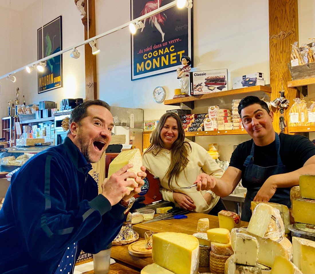Brian hamming it up with a wedge of cheese at a cheese shop