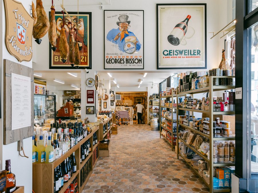 Inside The Cheese Store of Beverly Hills, with vintage posters and hanging prosciutto