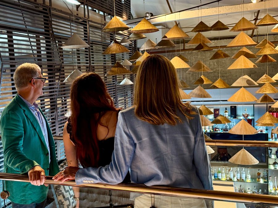 Guests admiring a hanging hat installation above a Beverly Hills bar