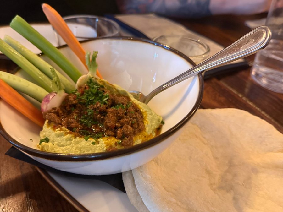 Hummus topped with spiced beef, with pita and crudités