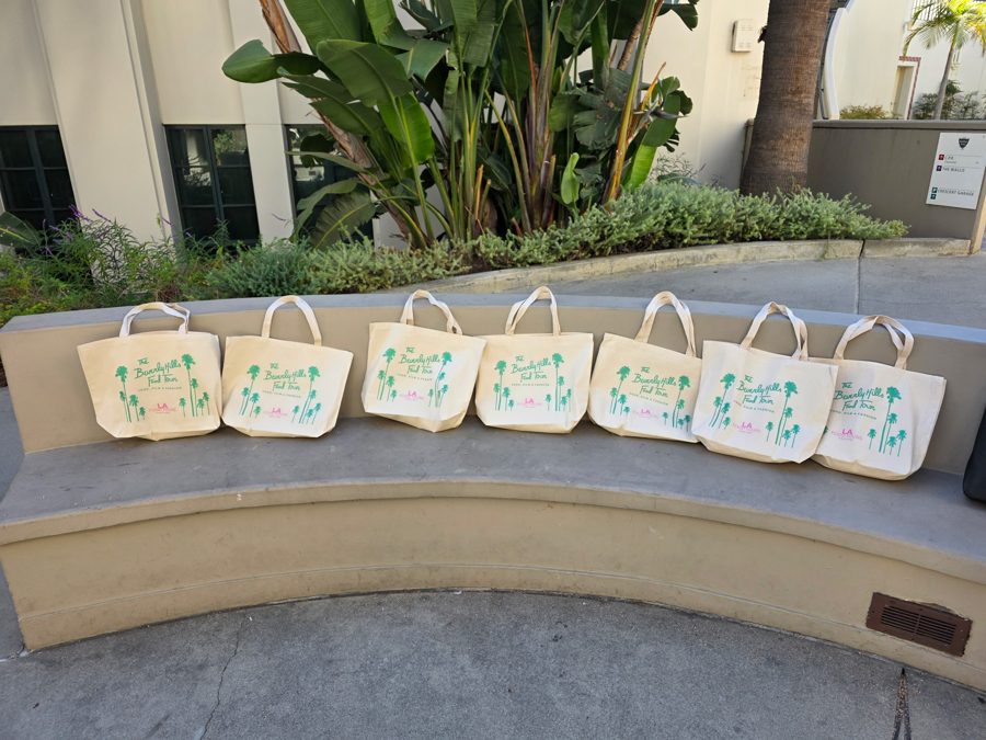 LA Food Tours tote bags lined up on a bench